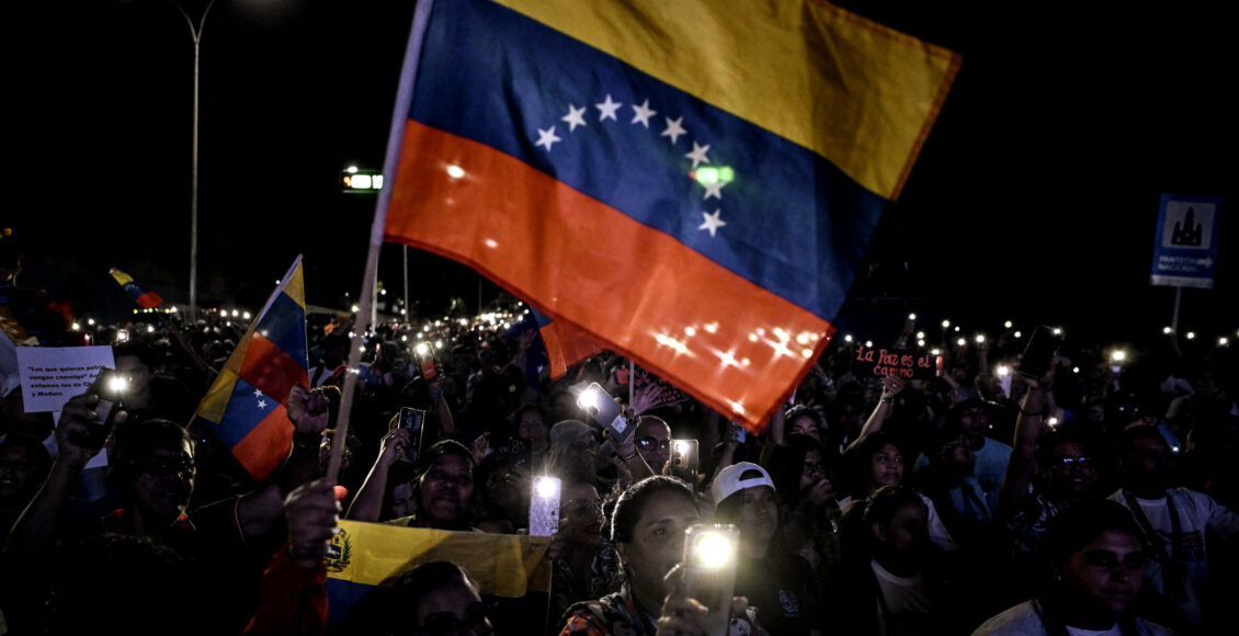 Apoiadores do presidente da Venezuela, Nicolás Maduro, agitam uma bandeira venezuelana durante um ato em defesa da paz em Caracas