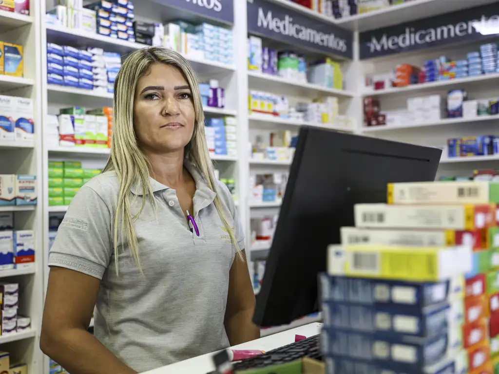 Atendente de farmácia posa para foto. A rotina de trabalho dela é em escala 6x1