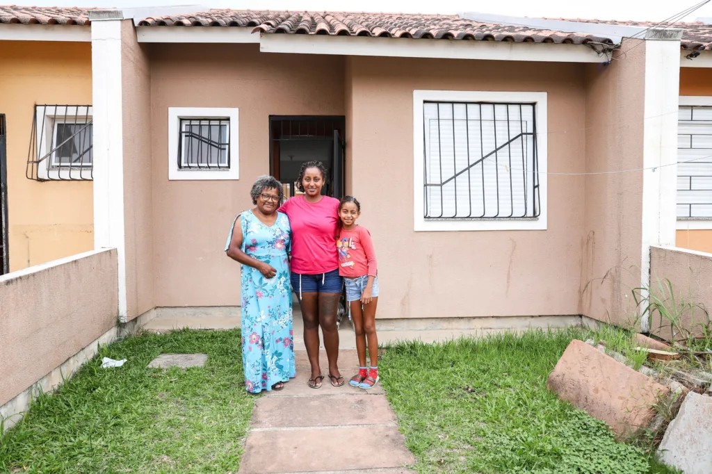 Em frente à casa alugada, três gerações de mulheres